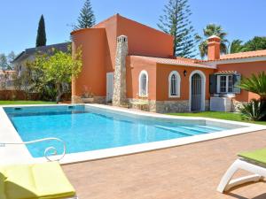 a villa with a swimming pool in front of a house at Villa in a quiet area with private pool near the golf courses and the marina in Vilamoura