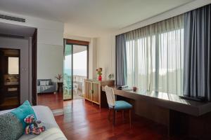 a living room with a couch and a desk with a window at Loligo Resort Hua Hin in Hua Hin
