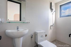 a bathroom with a sink and a toilet and a mirror at Maison de Rose in Quy Nhon