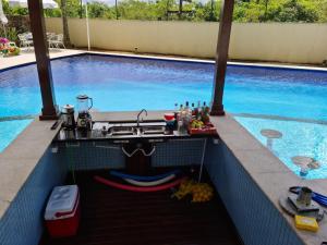 a swimming pool with a sink and a table next to it at Vista para o mar in Guarujá