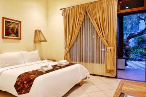 a bedroom with a bed and a large window at Rumah Mertua Heritage in Yogyakarta +42 photos