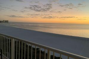 a view of the beach at sunset from a balcony at Admiralty House 1705S in Marco Island