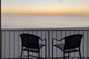 two chairs sitting on a balcony overlooking the ocean at Admiralty House 1705S in Marco Island +38 photos