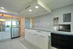 a large kitchen with white cabinets and a counter top at Sst3 #701 in Marco Island +24 photos