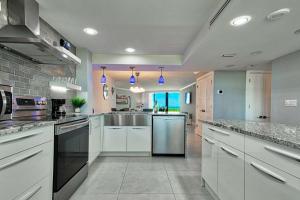 a large kitchen with white cabinets and stainless steel appliances at SSt3 #701 in Marco Island