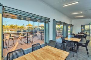 a restaurant with tables and chairs and a patio at RAC Exmouth Cape Holiday Park in Exmouth