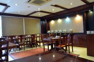 a restaurant with wooden tables and chairs and a chalkboard at Hotel Bhoomivilas in Agra