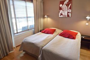 two beds in a room with a window at Holiday Club Tahko Spa Apartments in Tahkovuori