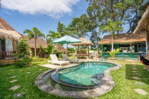 a backyard with a swimming pool and a house at Bali Brothers Guesthouse in Dalung