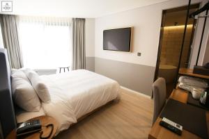 a hotel room with a bed and a television at Londoner Hotel Gwangan in Busan