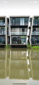 a building with a reflection in a body of water at Water with Candle Homestay in Wujie