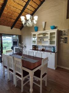 a kitchen with a wooden table and chairs and a chandelier at Invermooi Estate in Nottingham Road