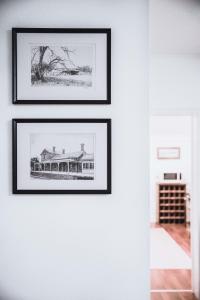 a row of framed photographs on a white wall at The Loft in Castlemaine