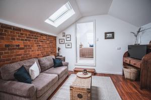 a living room with a couch and a brick wall at The Loft in Castlemaine