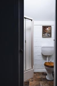 a bathroom with a toilet and a glass shower stall at The Loft in Castlemaine