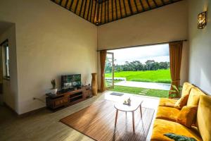 - un salon avec un canapé et une table dans l'établissement 2 BR Villa with open view of rice paddies & sunset, à Gianyar