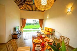 - un salon avec une table et de la nourriture dans l'établissement 2 BR Villa with open view of rice paddies & sunset, à Gianyar