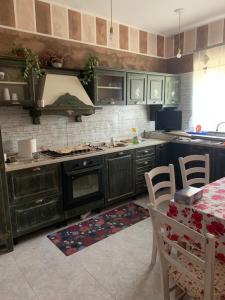 een keuken met zwarte kasten en een tafel met stoelen bij a casa di Anna in Aquino
