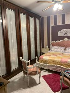 een slaapkamer met een bed en een stoel bij a casa di Anna in Aquino