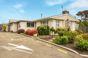 a house with a lot of flowers in front of it at Arcadia Motel in Christchurch +18 photos