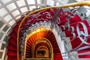 un escalier en colimaçon à l'orange et à l'or dans l'établissement Hôtel particulier Le DOGE - Relais & Châteaux, à Casablanca