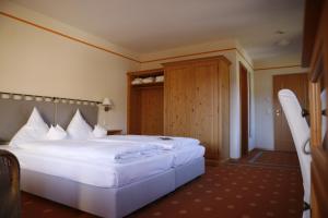 una camera con un grande letto bianco di Hotel Gut Schmelmerhof a Sankt Englmar