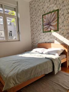 ein Schlafzimmer mit einem Bett mit einem Blumenbild an der Wand in der Unterkunft LUX Center of Belgrade 2 bedrooms, sleeps 6 - Free Parking in Belgrad