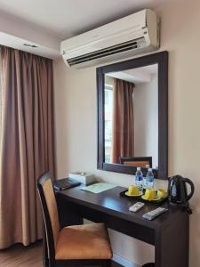 einen Schreibtisch in einem Hotelzimmer mit Spiegel in der Unterkunft 2 Inn 1 Boutique Hotel & Spa in Sandakan