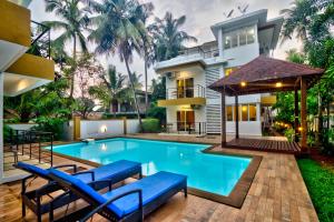 uma piscina no quintal de uma casa com uma villa em Rainforest Enclave, Arpora - 10 mins to Baga beach em Arpora