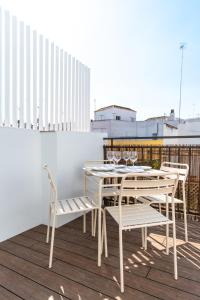 een witte eettafel en stoelen op een balkon bij Apartamentos Leoncillos in Sevilla
