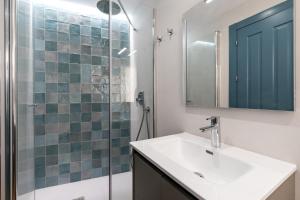 La salle de bains est pourvue d'un lavabo et d'une douche en verre. dans l'établissement Apartamentos Leoncillos, à Séville