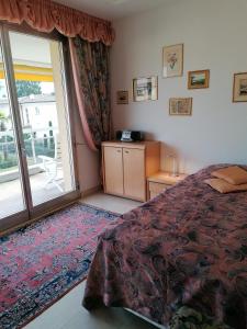 sypialnia z łóżkiem i przesuwanymi szklanymi drzwiami w obiekcie Condominio Golfo d'Oro w mieście Ascona +7 zdjęć