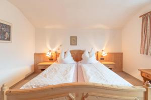 een slaapkamer met twee bedden met witte lakens bij Haus Starlet in Oberstdorf