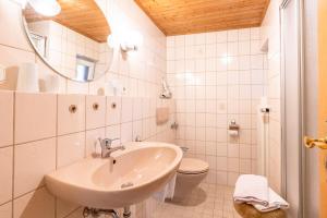 een witte badkamer met een wastafel en een toilet bij Haus Starlet in Oberstdorf +8 foto's