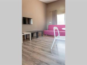 a living room with a pink couch and a table at Les Mini-Villas de Santa Giulia in Porto-Vecchio