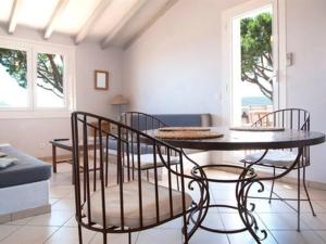 a dining room with a table and chairs in a room at Les Mini-Villas de Santa Giulia in Porto-Vecchio