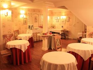 a room with tables and chairs with white and red table cloth at Le Château D'Osthoffen in Osthoffen