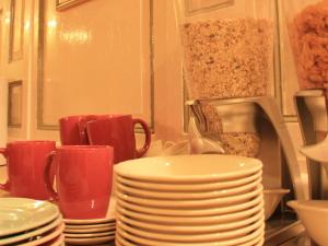 a pile of plates and cups on a kitchen counter at Le Château D'Osthoffen in Osthoffen