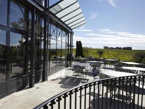 a balcony of a building with tables and chairs at Château la Rose Perriere in Lussac