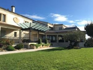 una casa grande con césped delante en Château La Rose Perrière en Lussac