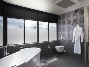 a bathroom with a bath tub and a toilet at Château la Rose Perriere in Lussac