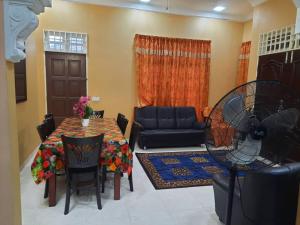 sala de estar con sofá y mesa con ventilador en Suria Damai Homestay, en Pasir Puteh