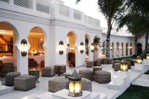 a lobby of a resort with chairs and palm trees at Baraza Resort and Spa Zanzibar in Bwejuu