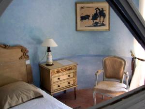 a bedroom with a bed and a dresser and a chair at Château d'Ortaffa in Ortaffa