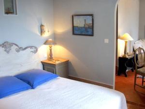 a bedroom with a bed and a table with a lamp at Château d'Ortaffa in Ortaffa