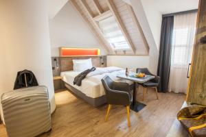 sypialnia z łóżkiem, stołem i krzesłami w obiekcie Boutiquehotel ThessoniClassicZürich w mieście Regensdorf