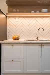 a kitchen with white cabinets and a sink at Maison de Rose in Quy Nhon