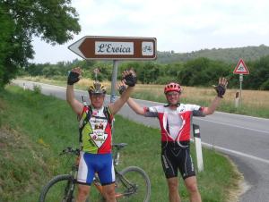 two men holding up a sign on a road at Fattoria Pieve a Salti in Buonconvento