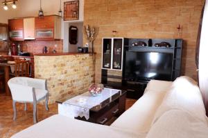 a living room with a couch and a large television at AMANDA in Selinitsa