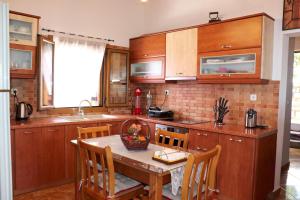 a kitchen with a wooden table and wooden cabinets at AMANDA in Selinitsa